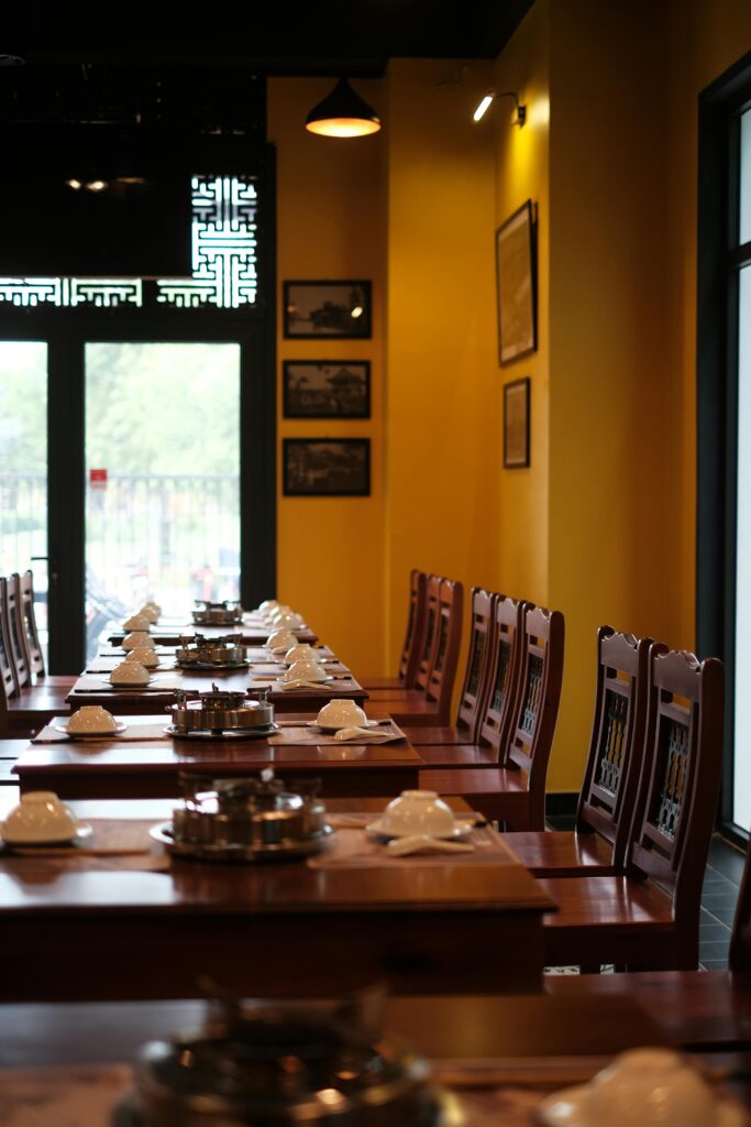 Elegant Dining Room Setup with Plates,Glasses, and Chairs at CravenChill Restaurant Kozhikode