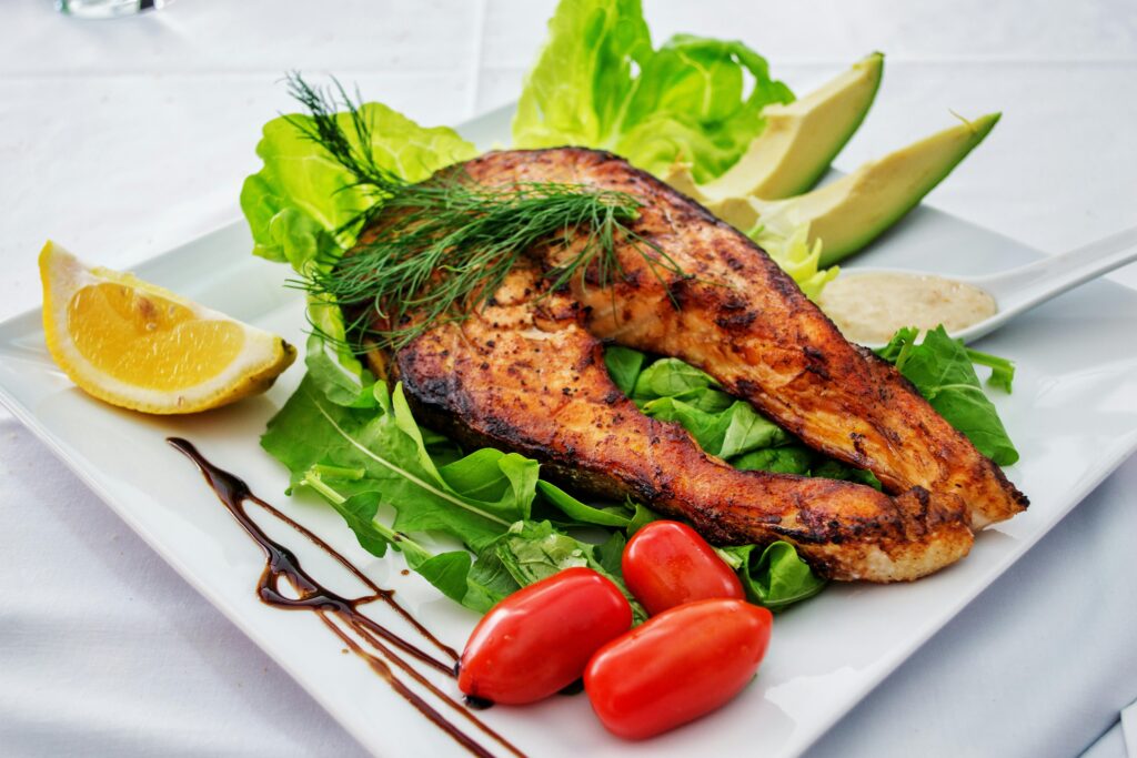Grilled fish fillet with salad and lemon - Kerala seafood at CravenChill Kozhikode