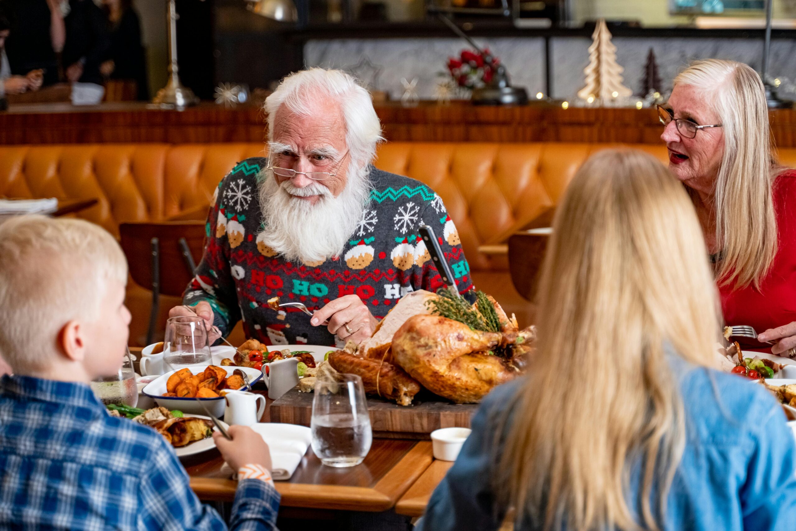 Family enjoying a festive meal in a Dubai restaurant, featuring joyful expressions and holiday decor.
