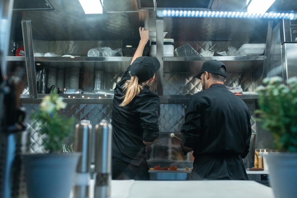 Two chefs working together in a commercial kitchen, preparing food.