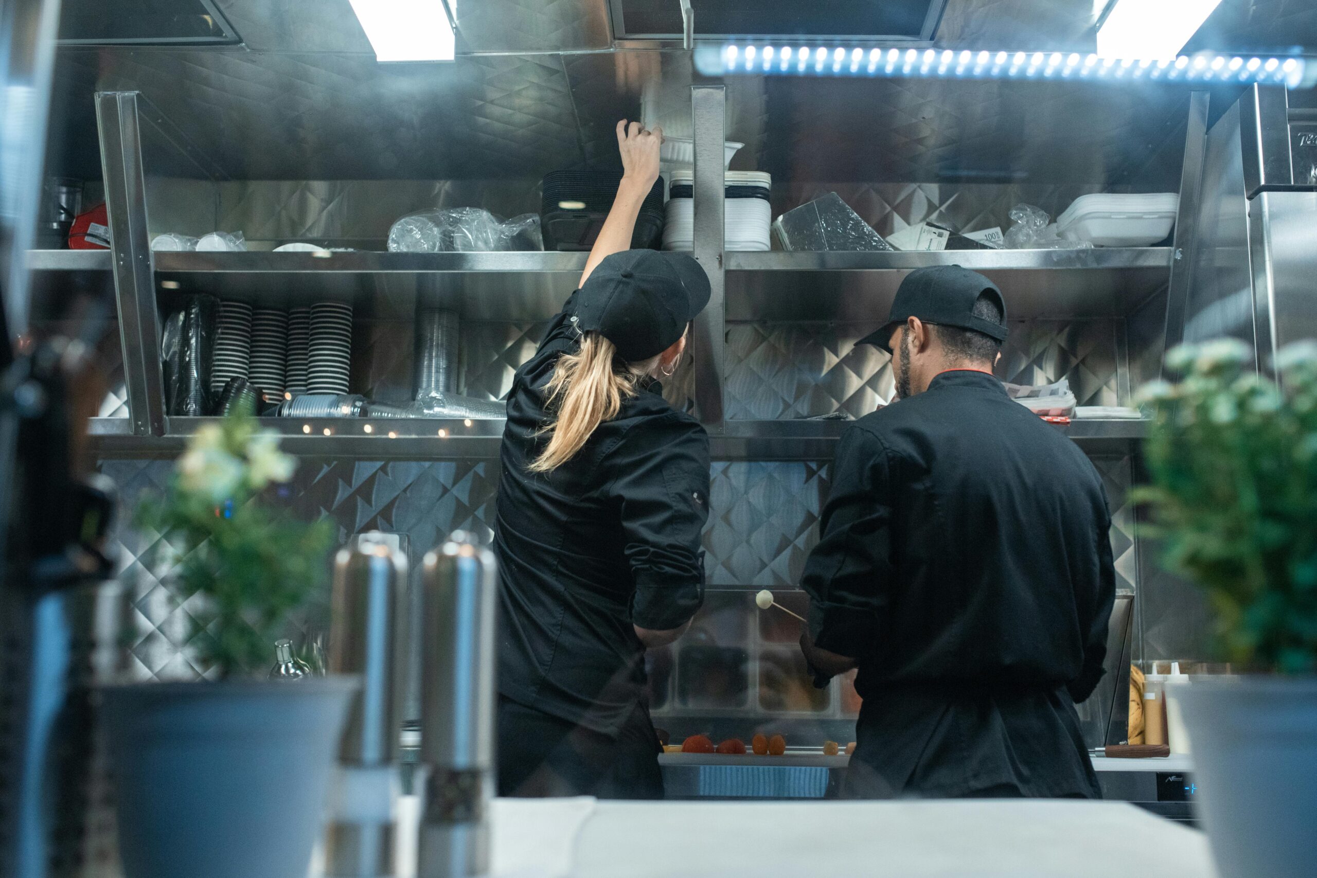 Two chefs working together in a commercial kitchen, preparing food.